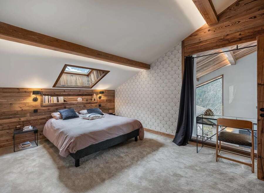 Experience rustic charm and modern comfort in this beautifully appointed bedroom, featuring a cozy bed with plush pillows and a stylish headboard.