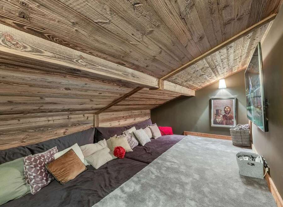 Experience rustic charm in this unique loft space, featuring a sprawling modular sofa adorned with an array of plush pillows for ultimate comfort.