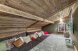 Experience rustic charm in this unique loft space, featuring a sprawling modular sofa adorned with an array of plush pillows for ultimate comfort.