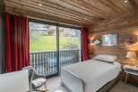 Experience cozy mountain living in this charming bedroom featuring rustic wooden walls and ceiling.