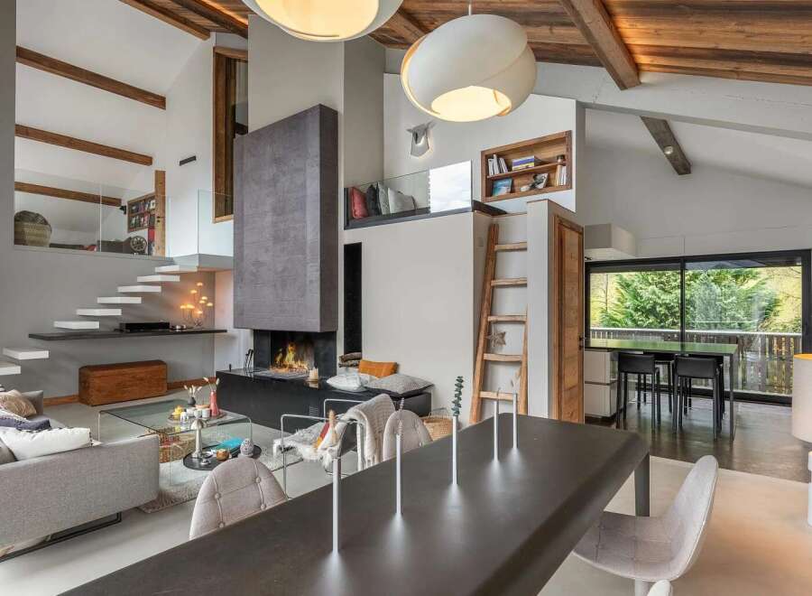 Experience luxury living in this stunning open-concept space, featuring a dramatic floor-to-ceiling fireplace and a floating staircase.