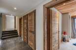 Step into a charming hallway featuring rustic wooden doors and a slate tile floor.