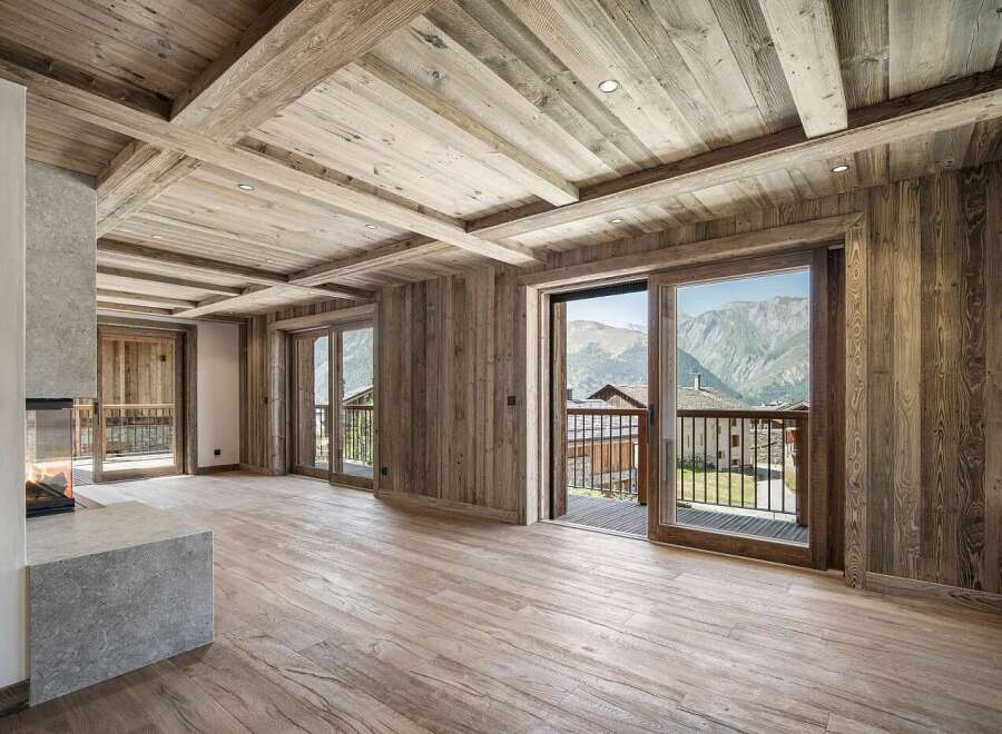 Experience luxurious mountain living in this stunning property featuring a modern stone fireplace and expansive wooden interiors.
