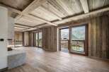 Experience luxurious mountain living in this stunning property featuring a modern stone fireplace and expansive wooden interiors.