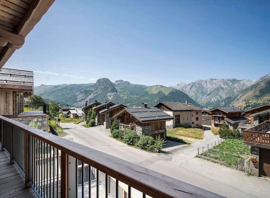 Experience the charm of alpine living in this picturesque village setting, featuring traditional stone and wood chalets nestled against a backdrop of majestic mountains.