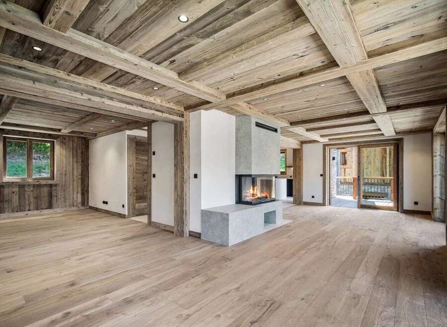Experience rustic elegance in this spacious living area, featuring a striking modern fireplace as the focal point.