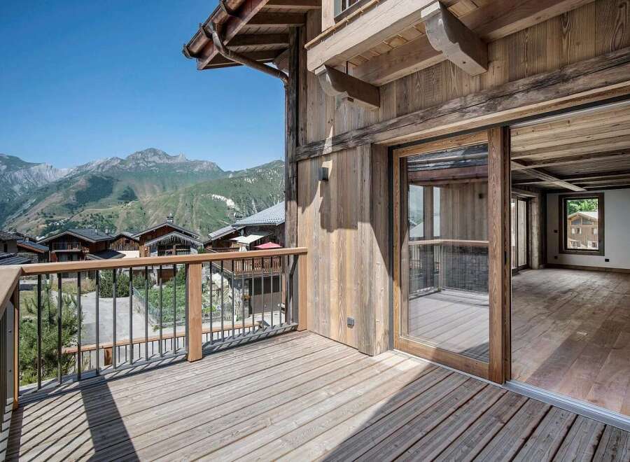 Experience breathtaking mountain vistas from this stunning wooden chalet, featuring a spacious balcony perfect for enjoying the alpine scenery.