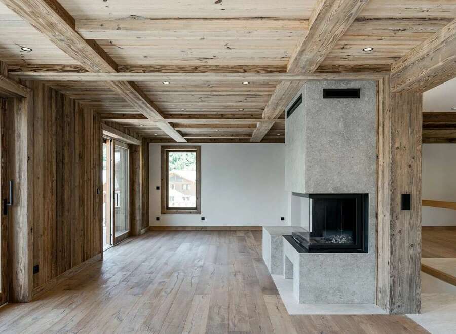Experience rustic luxury in this stunning mountain retreat, featuring a beautifully exposed wooden beam ceiling and warm, natural wood paneling throughout.