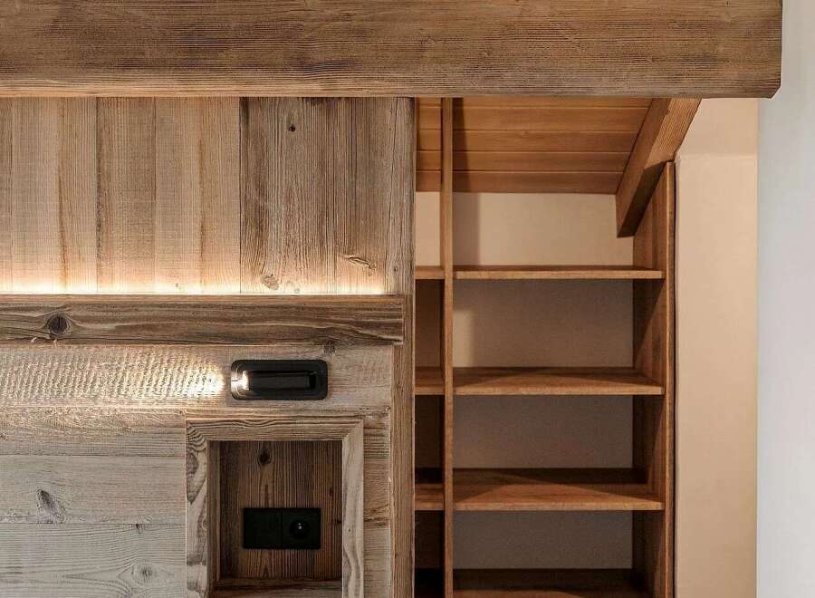 Experience rustic charm and modern convenience in this beautifully designed space, featuring exposed wooden beams and a built-in shelving unit.