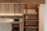 Experience rustic charm and modern convenience in this beautifully designed space, featuring exposed wooden beams and a built-in shelving unit.