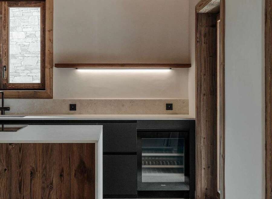 This modern kitchen boasts a rustic charm with its exposed wooden beams and a beautiful wooden island.