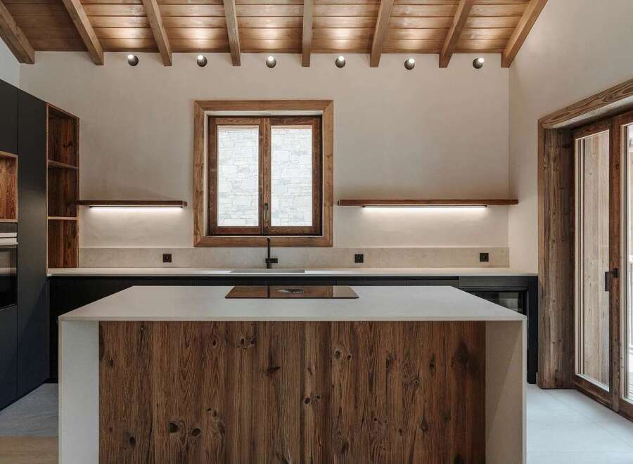 Experience rustic charm and modern convenience in this stunning kitchen, featuring a warm wooden island and exposed beam ceiling.