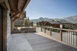 Experience breathtaking mountain views from this stunning property featuring a spacious wooden deck and a charming stone exterior.