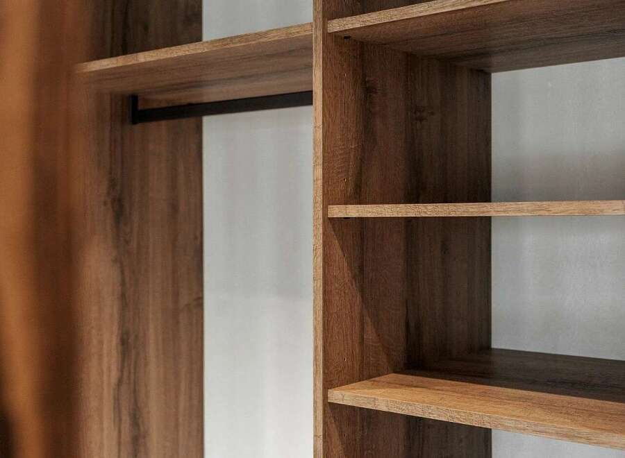 Discover organized living with this modern closet featuring a sleek hanging rod and ample shelving.