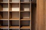 Discover the sophisticated storage solutions in this modern home, featuring a beautifully crafted wooden shelving unit.