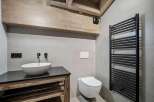 Experience modern luxury in this stunning bathroom, featuring a sleek vessel sink atop a rustic wooden vanity.