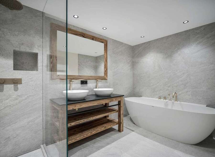 Experience modern luxury in this stunning bathroom, featuring a freestanding soaking tub and a spacious walk-in shower with sleek grey tiling.