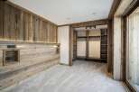 Experience rustic luxury in this bedroom featuring warm, natural wood paneling and integrated lighting.