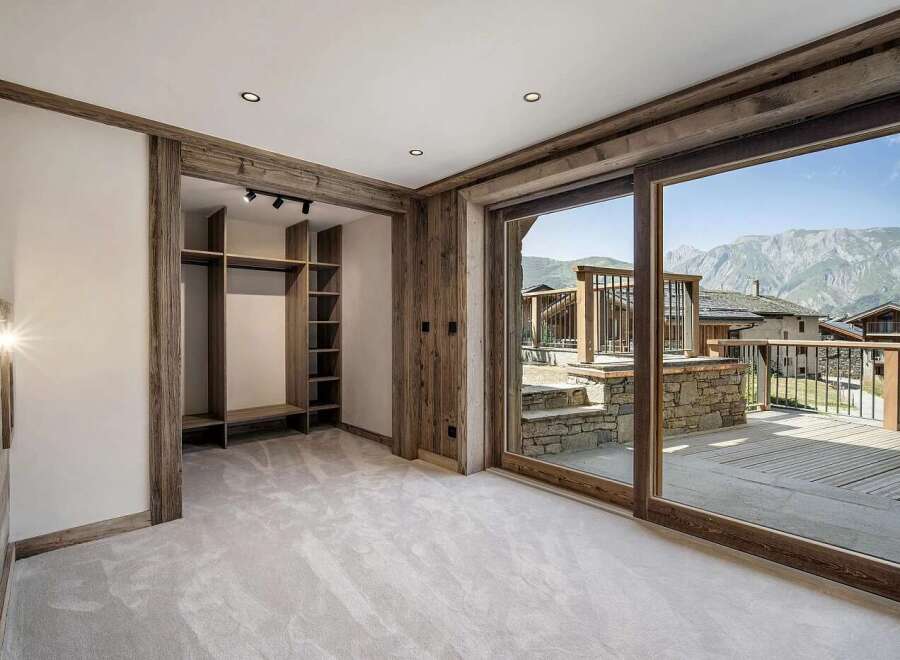 Experience luxury mountain living in this stunning bedroom featuring a spacious walk-in closet with ample shelving and a hanging rod.
