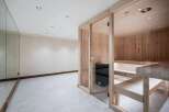 Experience ultimate relaxation in this modern home spa featuring a beautifully crafted wooden sauna with glass doors.