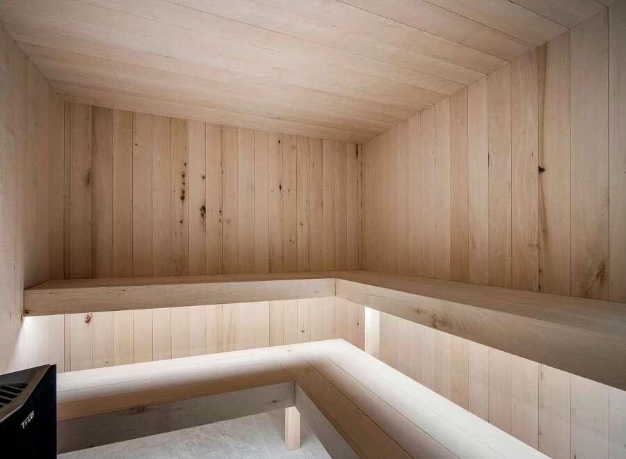 Experience ultimate relaxation in this modern, all-wood sauna, featuring natural light and comfortable bench seating.
