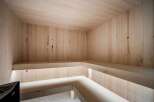 Experience ultimate relaxation in this modern, all-wood sauna, featuring natural light and comfortable bench seating.