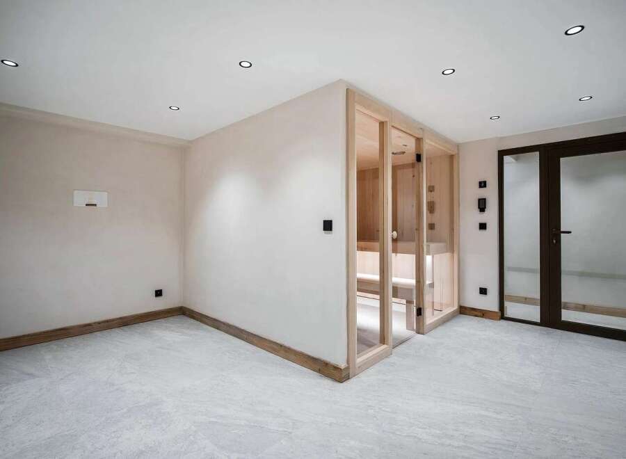 Experience ultimate relaxation in this modern home featuring a luxurious glass-enclosed sauna.