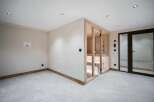 Experience ultimate relaxation in this modern home featuring a luxurious glass-enclosed sauna.