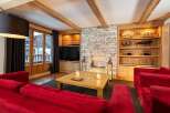 Experience luxurious mountain living in this stunning living room, featuring a cozy stone fireplace and elegant wooden beams.
