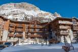 Experience luxury mountain living in this stunning ski resort property, featuring a grand wooden and stone facade that blends seamlessly with the snow-capped peaks.
