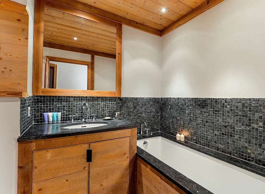 Experience luxury in this stunning bathroom featuring a deep soaking tub and a sleek vanity with a granite countertop.