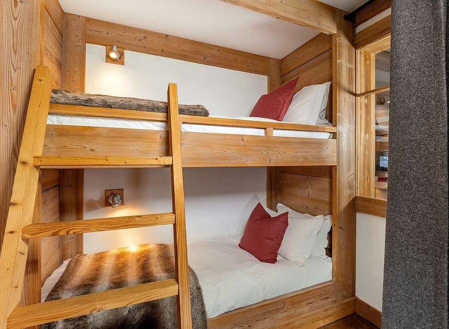 Experience cozy mountain living in this charming wooden bunk room, perfect for families or groups.