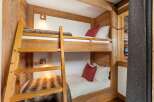 Experience cozy mountain living in this charming wooden bunk room, perfect for families or groups.