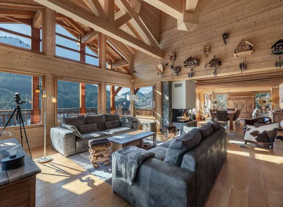 Experience luxurious mountain living in this stunning chalet, featuring a grand living area with a modern fireplace and breathtaking panoramic views.