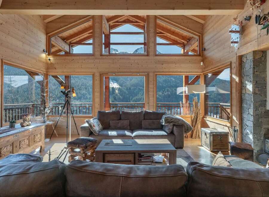 Experience breathtaking mountain views from this stunning wooden chalet living room.