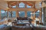 Experience breathtaking mountain views from this stunning wooden chalet living room.