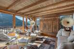 Experience breathtaking mountain views from this stunning living room, featuring a cozy fireplace and expansive windows.