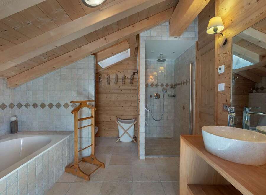 Experience rustic charm in this mountain-view bathroom featuring a luxurious soaking tub and a separate glass-enclosed shower.