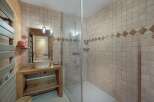 Experience rustic charm in this bathroom featuring a stone vessel sink atop a wooden vanity.