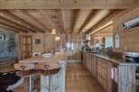 Experience rustic luxury in this stunning mountain chalet kitchen, featuring warm wooden cabinetry and exposed beams that create a cozy, inviting atmosphere.
