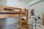 This charming children's room features a sturdy wooden bunk bed, perfect for siblings or sleepovers.
