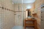This charming bathroom features a spacious walk-in shower with elegant tiled walls and a decorative diamond accent band.