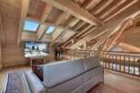 Experience the ultimate in alpine living with this stunning attic loft featuring exposed wooden beams and expansive skylights that flood the space with natural light.