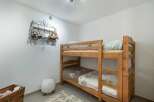 This charming children's bedroom features a sturdy wooden bunk bed, perfect for siblings or sleepovers.