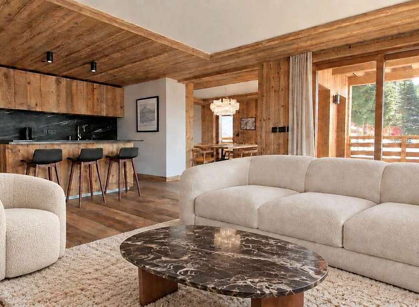 Experience luxurious mountain living in this beautifully appointed living space, featuring a plush cream sofa and a cozy armchair perfect for relaxation.