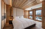 Experience luxury mountain living in this stunning bedroom featuring a plush king-sized bed and a dramatic upholstered headboard.