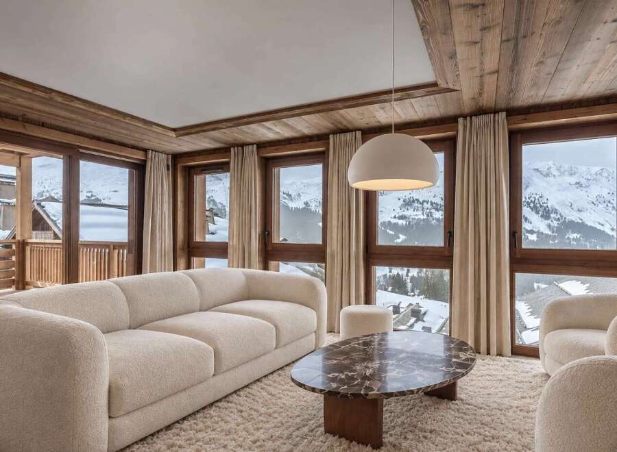 Experience luxury mountain living in this stunning living room, featuring a plush cream sofa and a unique marble coffee table.