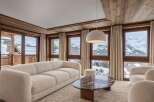 Experience luxury mountain living in this stunning living room, featuring a plush cream sofa and a unique marble coffee table.