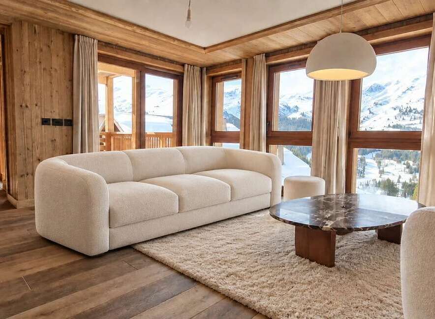 Experience luxurious mountain living in this beautifully appointed living room, featuring a plush cream sofa and a striking marble coffee table.