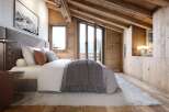 Experience rustic luxury in this charming mountain bedroom, featuring exposed wooden beams and a cozy, inviting atmosphere.